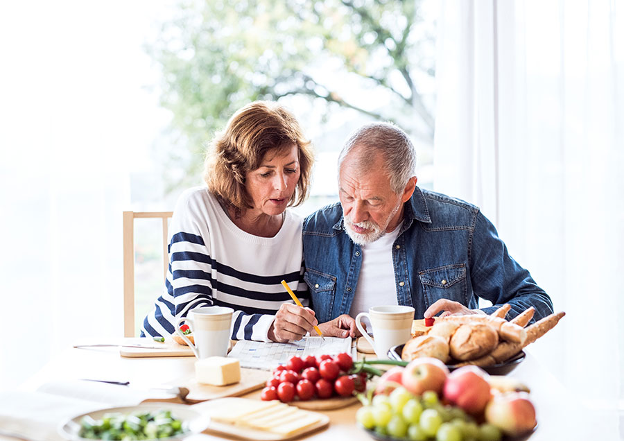 Middle-age-couple-solving-crossword-puzzle