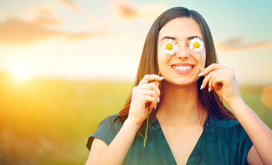 YOUNG-WOMAn-COVERING-HER-EYES-WITH-DAISIES