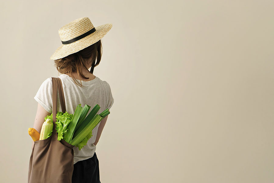 Young-woman-carrying-groceries-in-fabric-bag