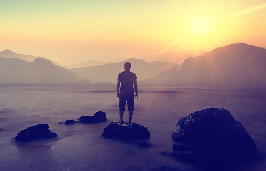 man-watching-sunrise-over-mountains