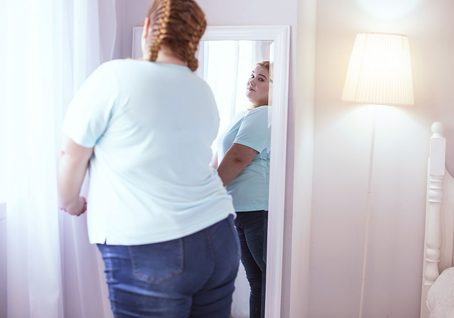 overweight-woman-looking-at-mirror