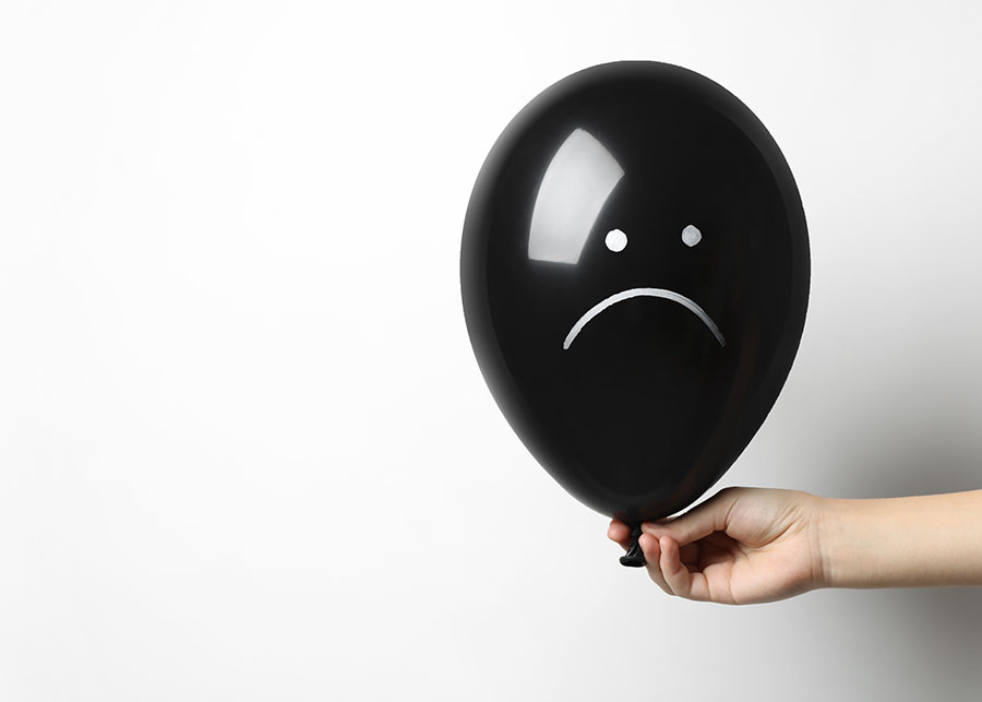 woman-holding-sad-faced-balloon